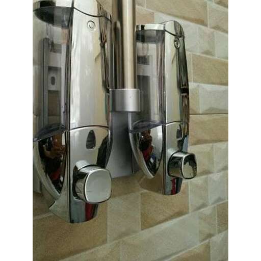 a chrome water dispenser mounted on a wall.