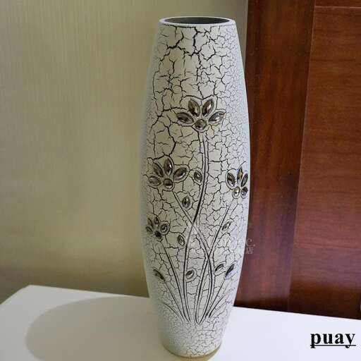 a vase with a flower design on it on a table.