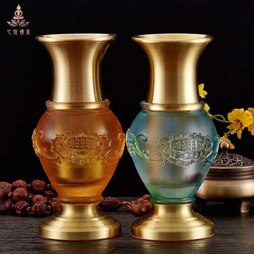 two gold colored vases on a black background