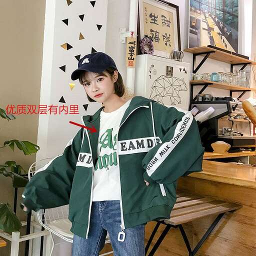 a girl in a green jacket and blue jeans holding a bat.
