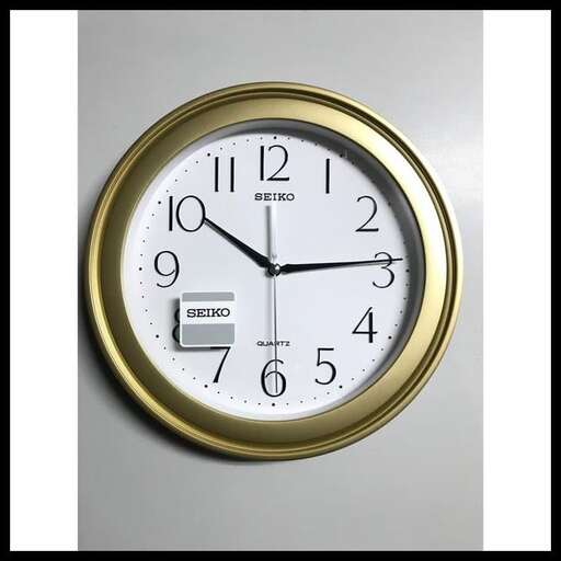 a clock with a gold frame and a black frame.