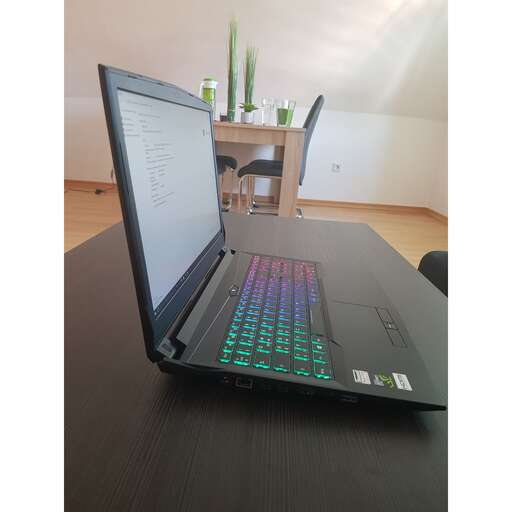a laptop computer sitting on a table in a room.