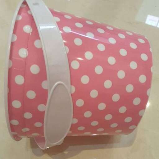 a pink polka dot bag with a strap.