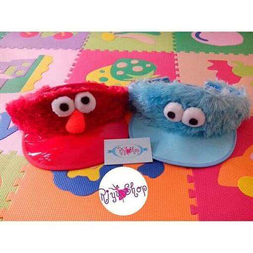 two blue and red stuffed animals sitting on top of a colorful table.