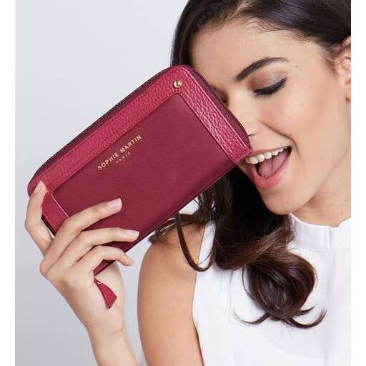 a woman holding a small purse in her hand.