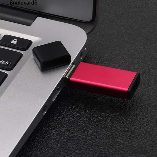 a red usb port is plugged into a computer keyboard.