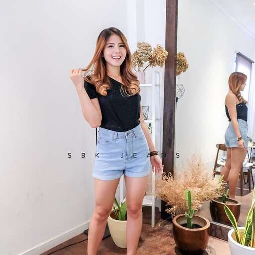 person in a black top and denim shorts