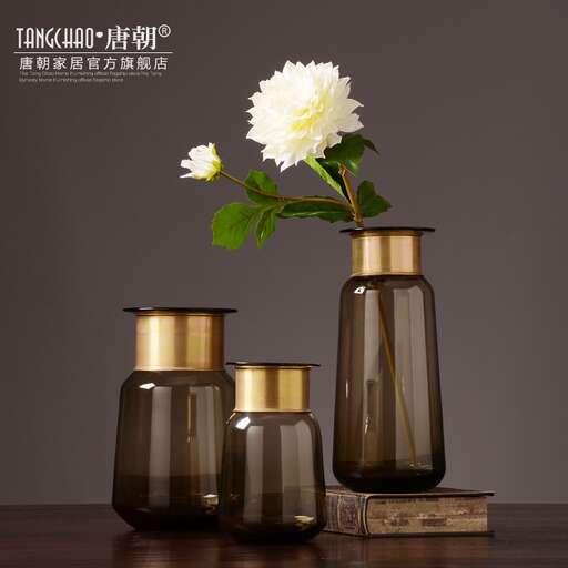 a white flower in a brown glass bottle.