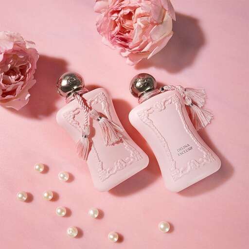 pink perfume bottle with pearls in a pink background