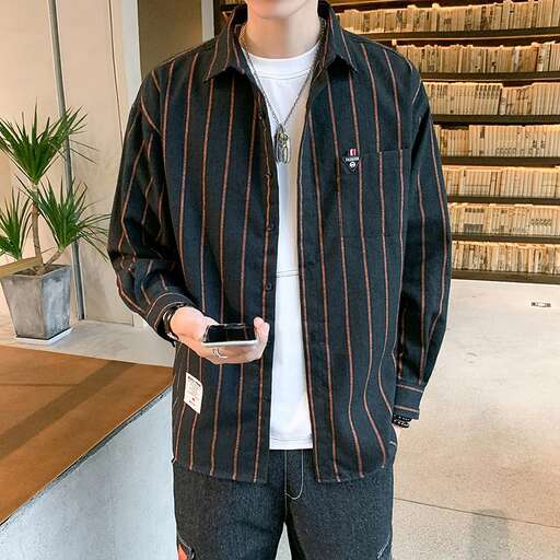 a man standing in a room holding a cell phone.