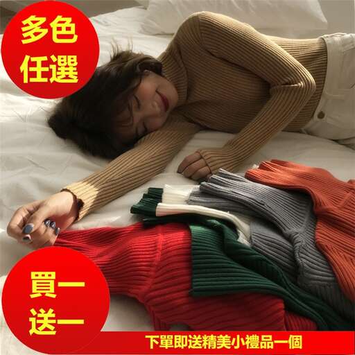 a woman laying on a bed with a sweater on her stomach.