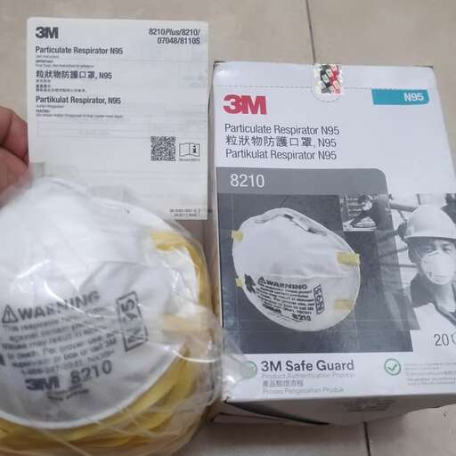 a person holding a bag of yellow wire and a white box.
