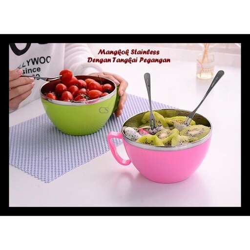 a pink bowl filled with green beans and a spoon.