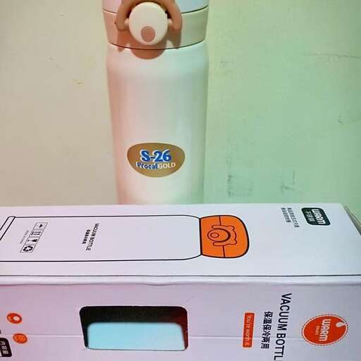a white and orange water bottle sitting on top of a box.