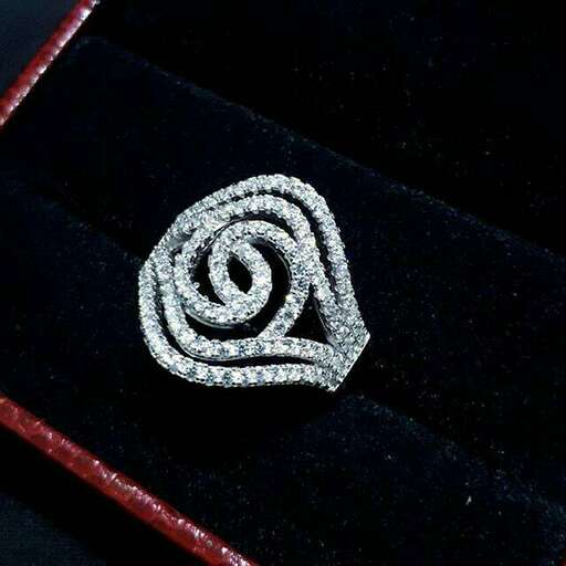 a beautiful silver brooch with a white and red stone in the center.