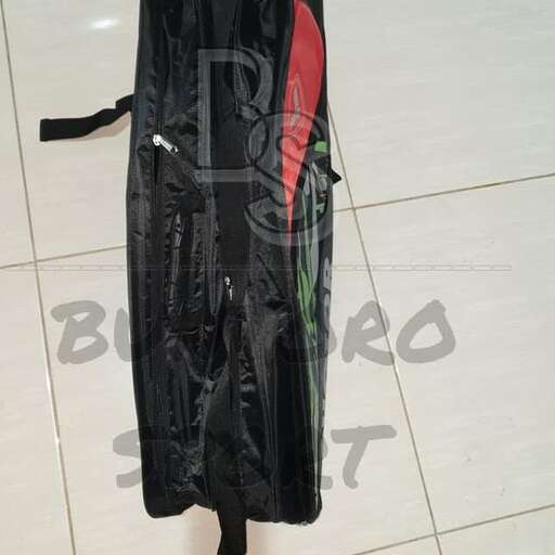 a black suitcase with a red and black bag on the floor.