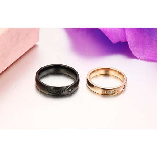 a pair of wedding rings with a pink paper bag.