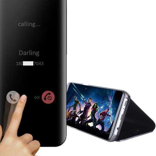 a person pointing at a smart phone with a picture of a movie on it.