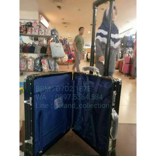 a man pushing a cart with a blue suitcase.
