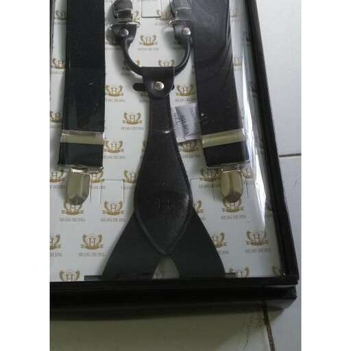 a pair of scissors in a box on a tile floor.