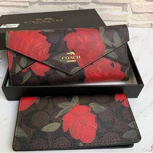 a beautiful red rose print clutch bag with a black leather strap.