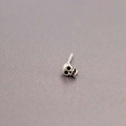 a tiny silver ball with a skull on it.