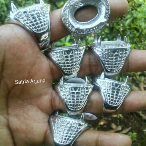 a hand made silver pendant with a design on the front and back.