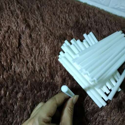 a close up of a person putting a piece of paper on a rug.