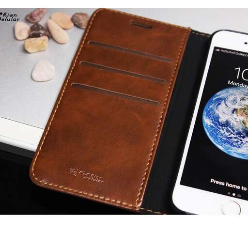 a brown leather wallet sitting next to a white iphone.