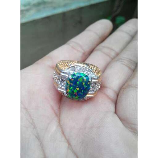 a ring with a green sapphire and diamond.