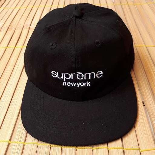 a black baseball cap with a white logo on it.