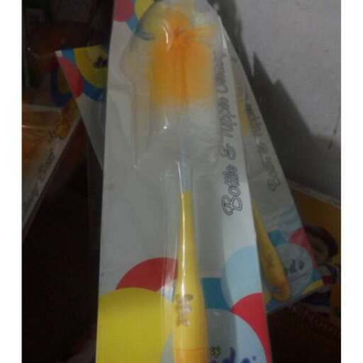 a plastic bag with a yellow handle and a yellow toothbrush in it.