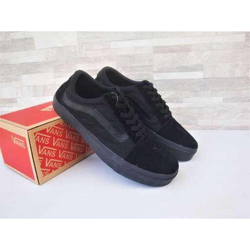 a pair of black sneakers sitting on top of a white counter.