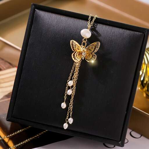 a butterfly necklace with a pearl necklace and pearls.