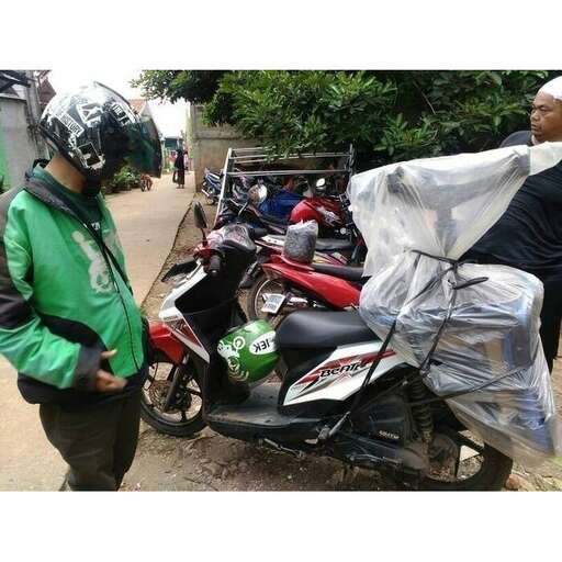 a man standing next to a motorcycle with a helmet on.