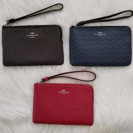 a red purse and a purse on a white blanket.
