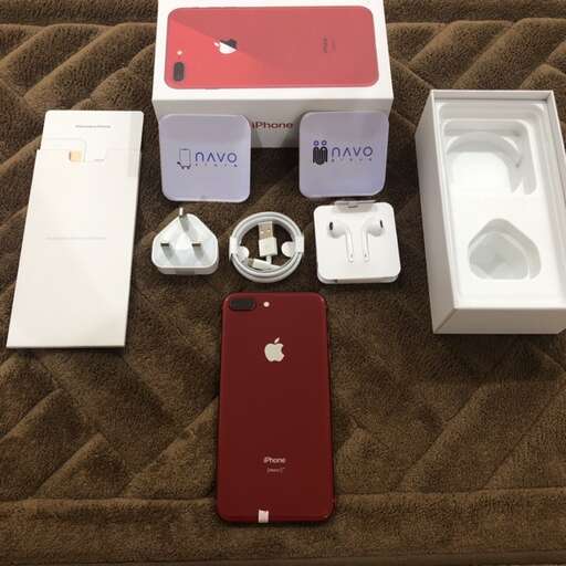 a red iphone and a white box on a carpet.