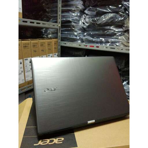 a black laptop sitting on top of a cardboard box.