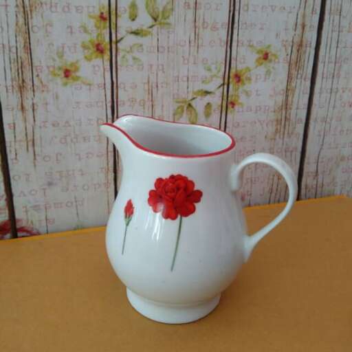 a red flower pot with a red flower on it.