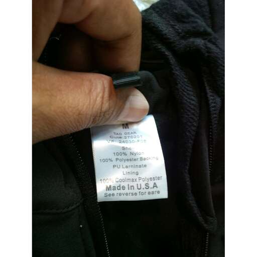 a person holding a zippered pocket with a black zipper.