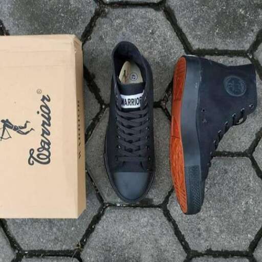 a pair of sneakers sitting next to a cardboard box.