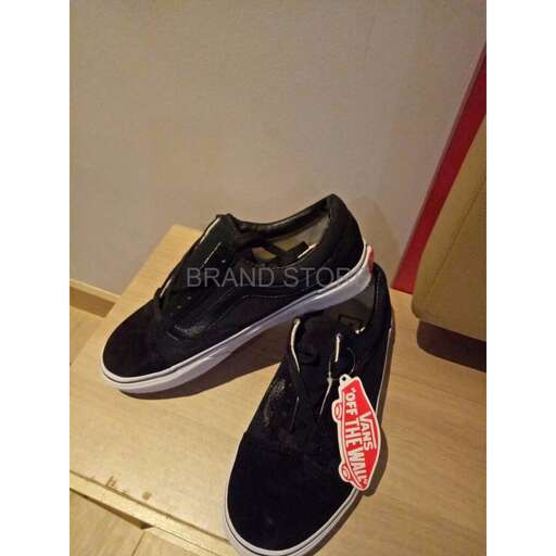 a pair of black canvas shoes with a red tag on the front.