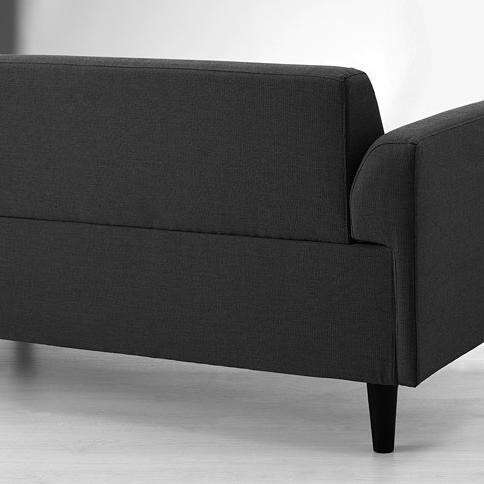 a black couch sitting on top of a white floor.
