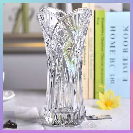 a glass vase sitting on a table next to books.