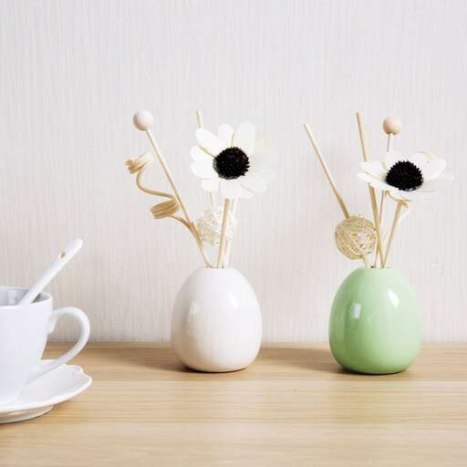 a white vase with flowers in it