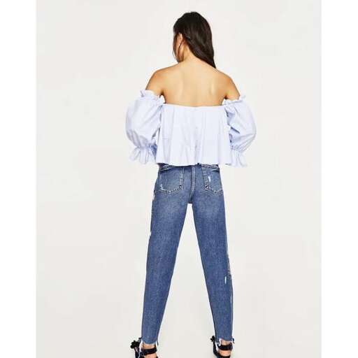 off the shoulder top with a ruffled top and high - waisted jeans