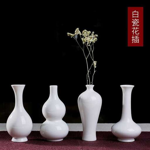 three white vases with flowers in them.