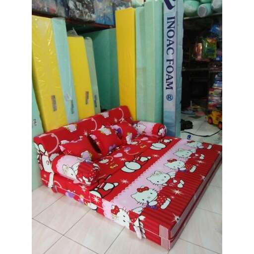 a red couch sitting on top of a white tile floor.