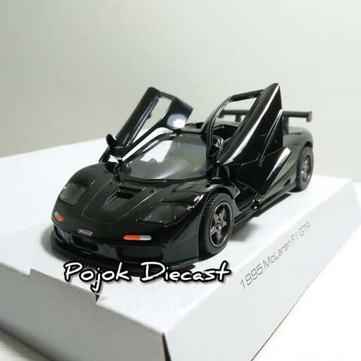 a black toy car sitting on a white box.