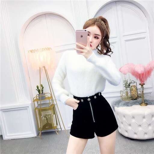 a girl in black shorts holding a cell phone.
